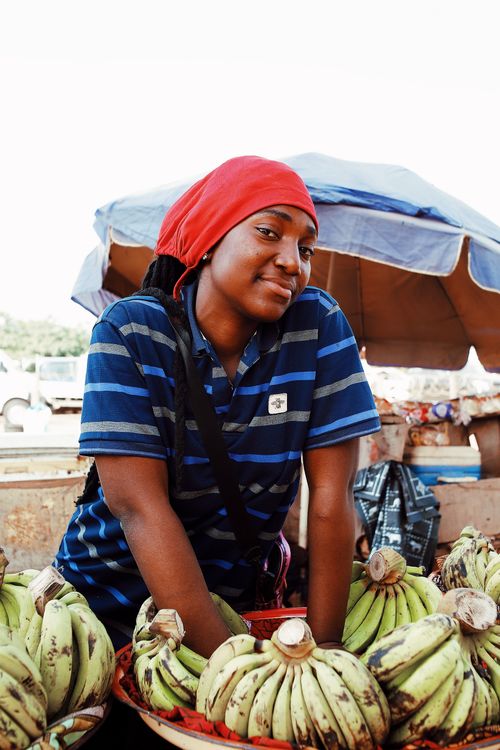 Free Portrait of a smiling woman selling bananas at an outdoor market in Abuja, Nigeria. Stock Photo