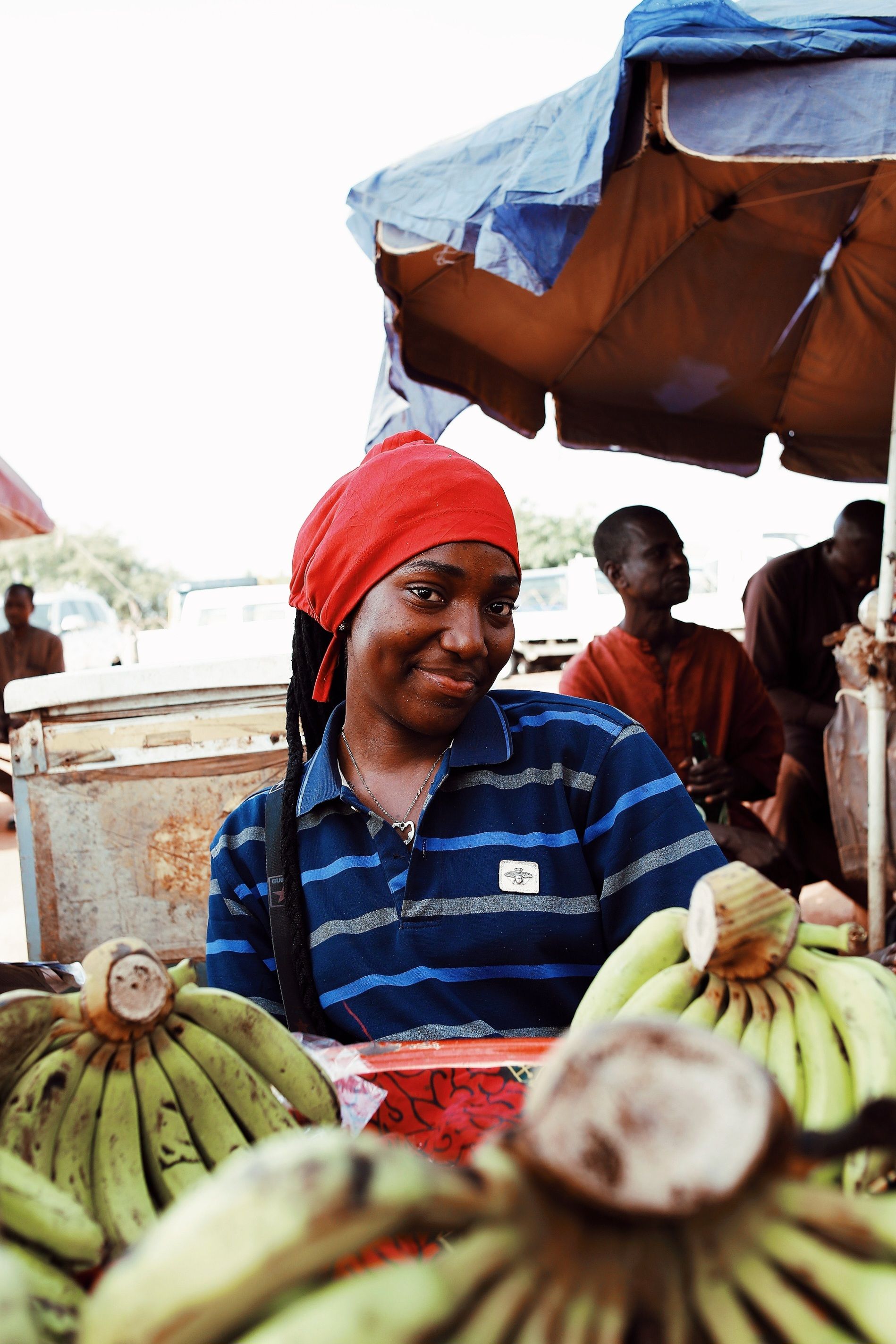 Une vendeuse sourit avec sa pile de bananes sur son étal