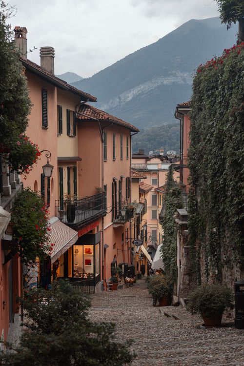 Free Picturesque street in Como, Italy with colorful buildings and mountain view. Stock Photo