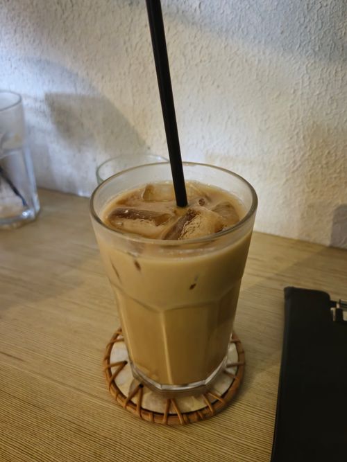 Free A glass of iced coffee with ice cubes and a straw on a wooden table. Refreshing and inviting. Stock Photo