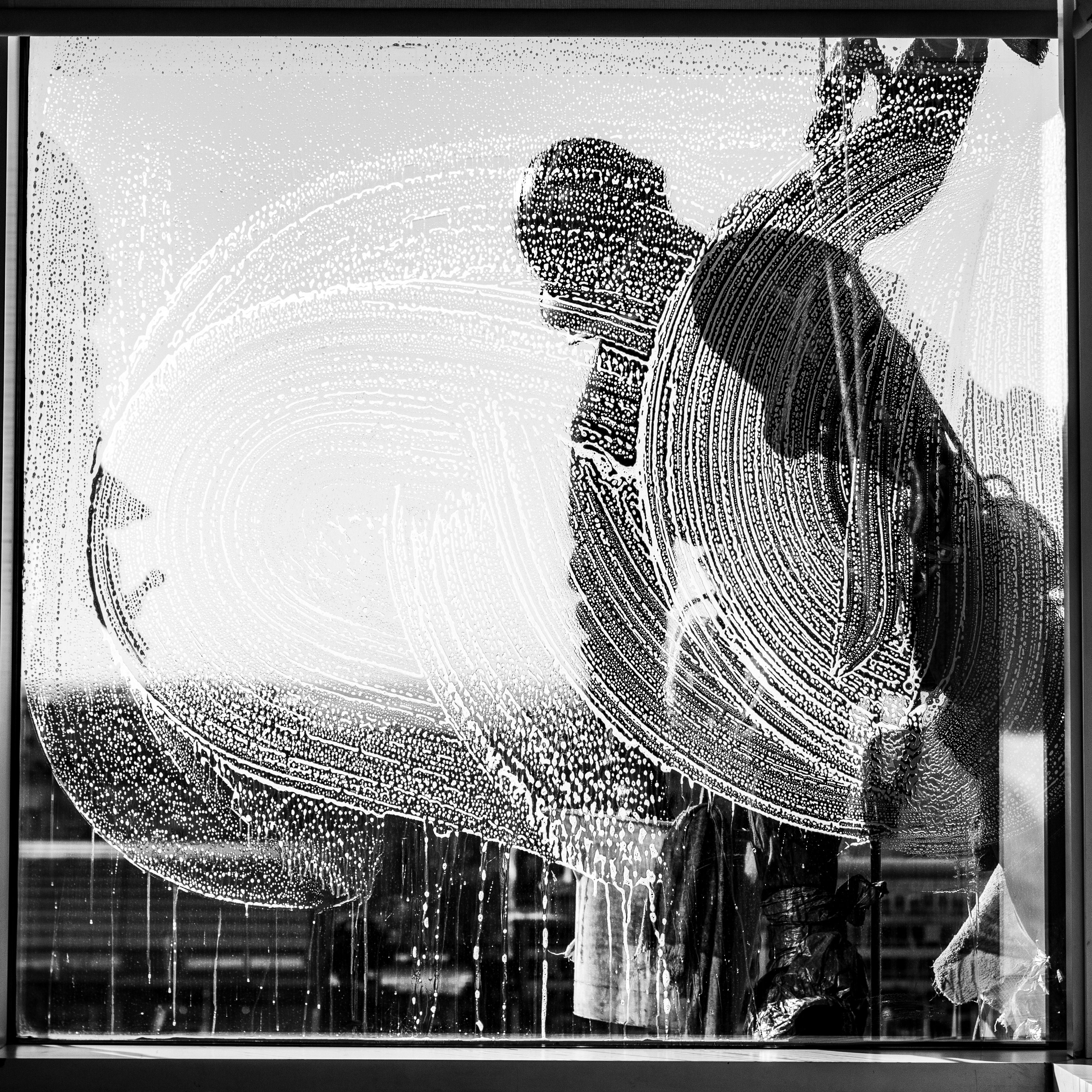 A window cleaner captured against a soapy window in Buenos Aires, Argentina.