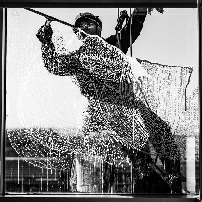 High-rise window cleaner captured in monochrome, showcasing urban city life in Buenos Aires.