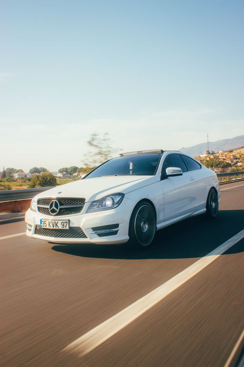 Free White Mercedes-Benz car driving on a scenic highway in İzmir, Türkiye. Modern automotive shot. Stock Photo