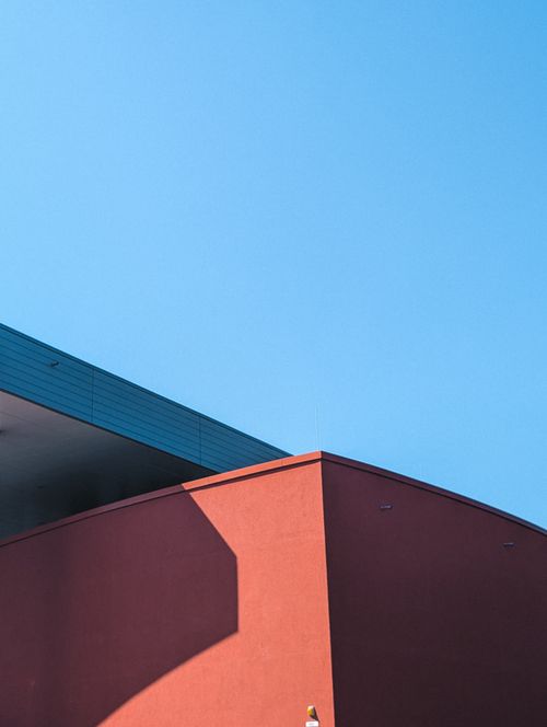 Free Abstract view of a red building facade with sharp lines under clear blue sky, showcasing minimalist architecture. Stock Photo