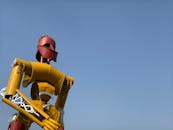 Vibrant Iron Robot Sculpture Against Blue Sky