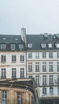 A rainy day in Paris showcasing iconic Haussmannian buildings with classic architecture style.