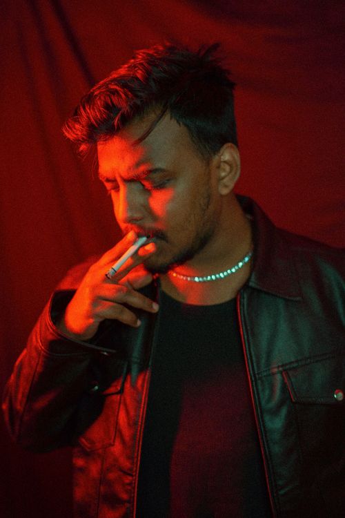 Free Moody portrait of a man smoking in dramatic lighting, capturing a contemplative moment. Stock Photo