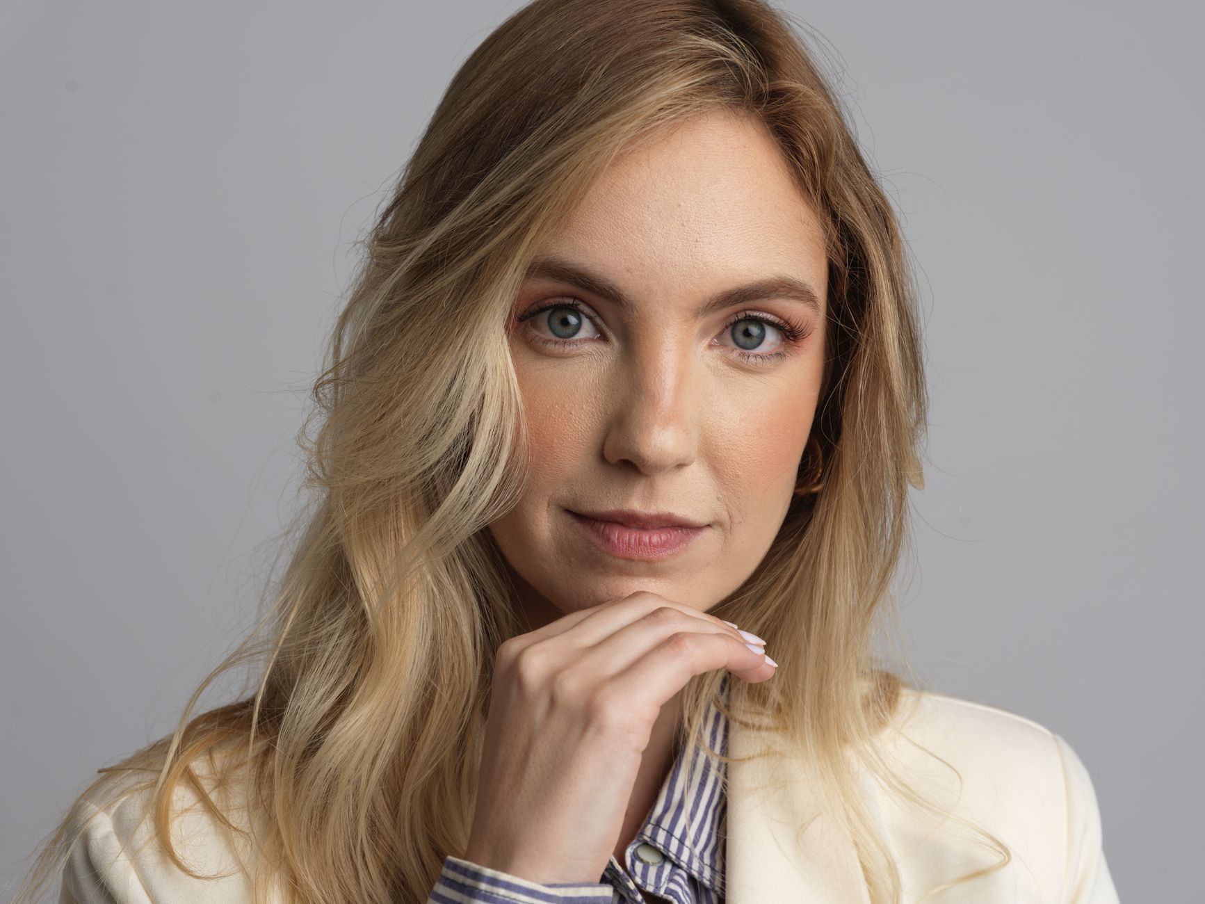 Close-up portrait of a blonde woman wearing a blazer, conveying professionalism.