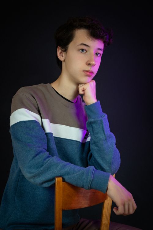Free Teenager in a contemplative pose against a dark background. Stock Photo