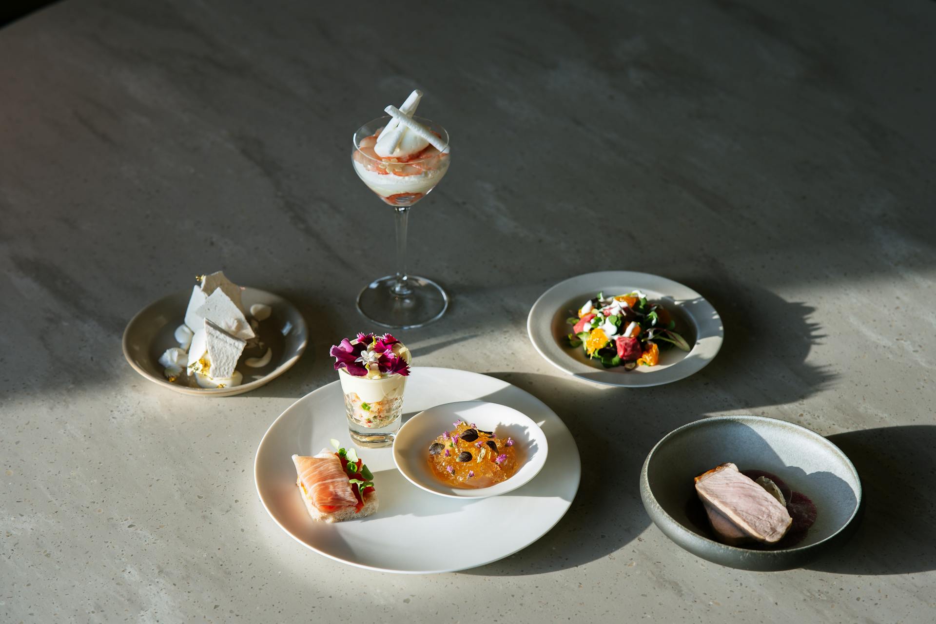 Luxurious gourmet food arrangement with diverse exquisite dishes beautifully plated on a table.