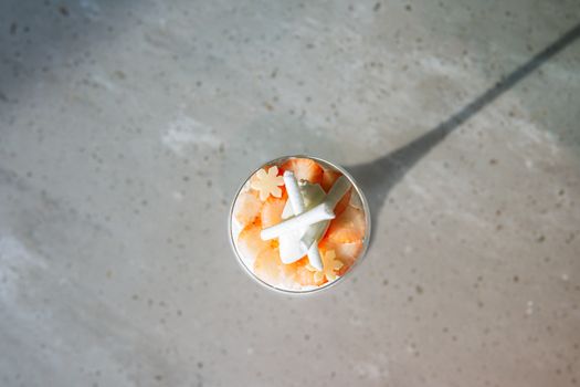 Top view of a dessert with an airplane decoration casting a shadow.