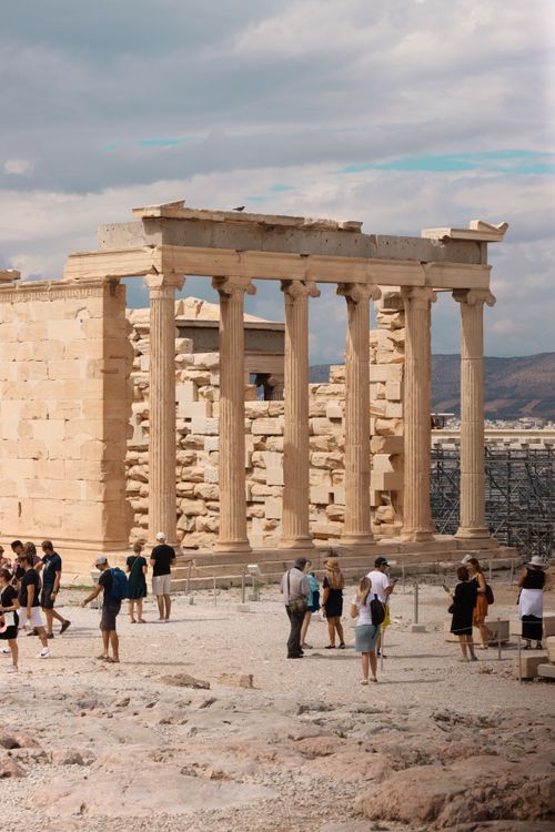 Free Tourists visiting the ancient Parthenon ruins in Athens, Greece under a cloudy sky. Stock Photo
