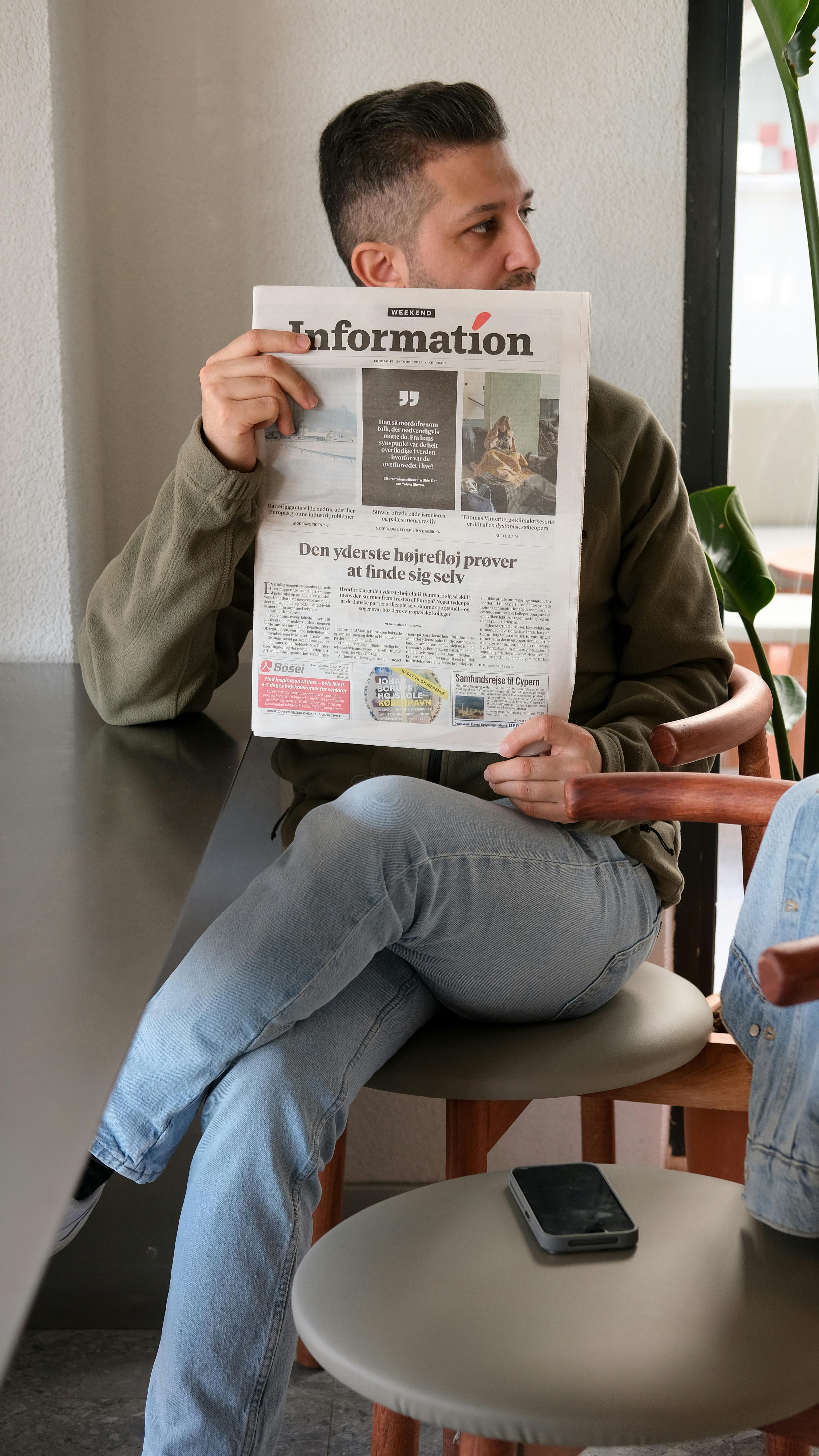 man reading newspaper in a cozy cafe setting