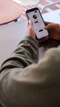 Close-up of individual using smartphone for social media in casual setting.