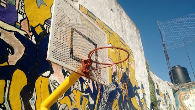 A rustic basketball hoop set against vibrant graffiti in Buenos Aires, Argentina.