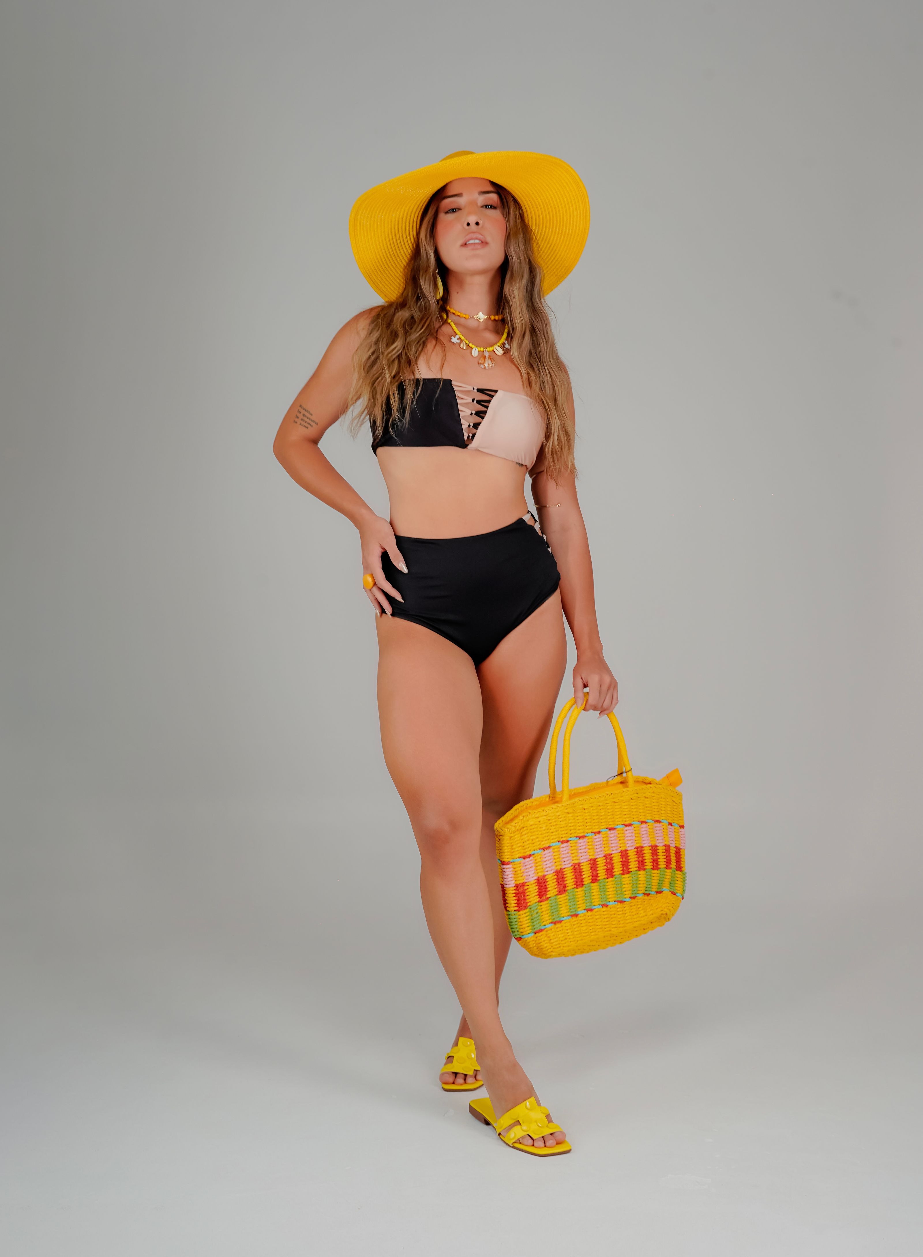 Modelo em traje de praia moderno com acessórios, perfeito para o clima de verão.