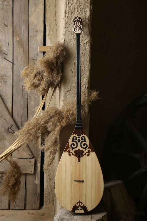 Free Traditional Kazakh dombyra placed against rustic background, showcasing cultural heritage. Stock Photo