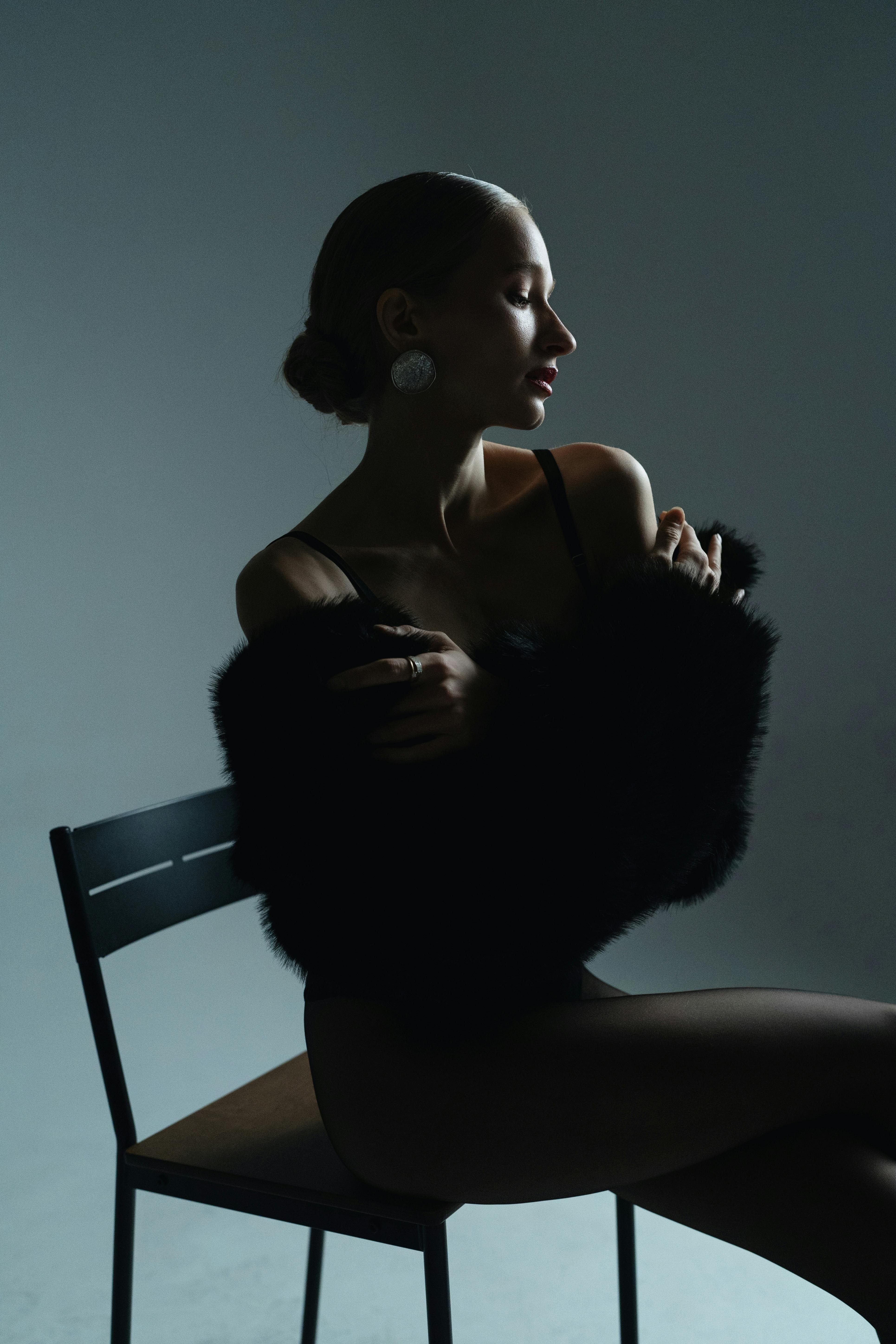 Striking studio portrait of a female model in moody lighting, embodying modern glamour.