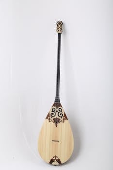 A traditional Kazakh dombyra with intricate designs on a white backdrop.