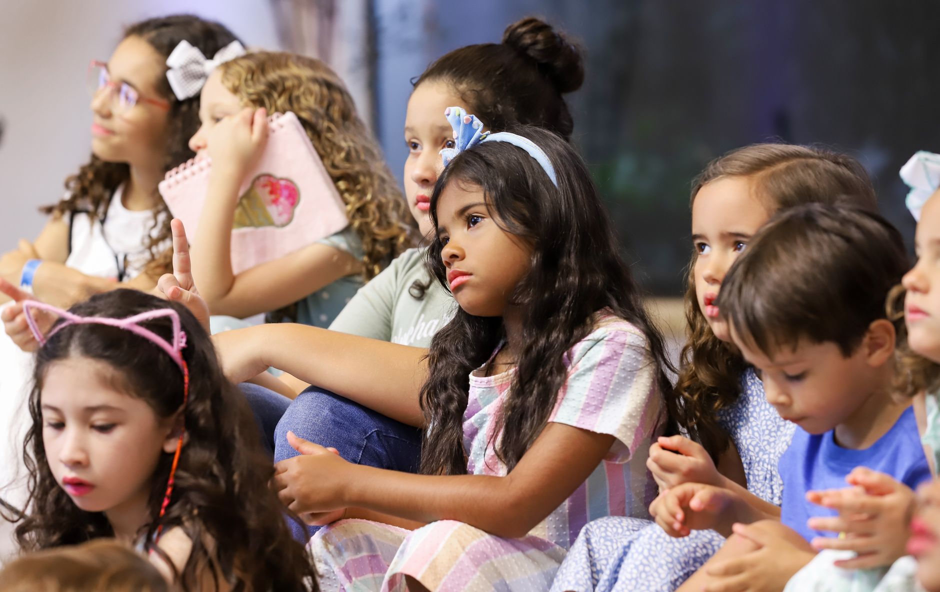 school talent show organizer cairo — Children attentively sitting in a classroom, engaged in learning activities.