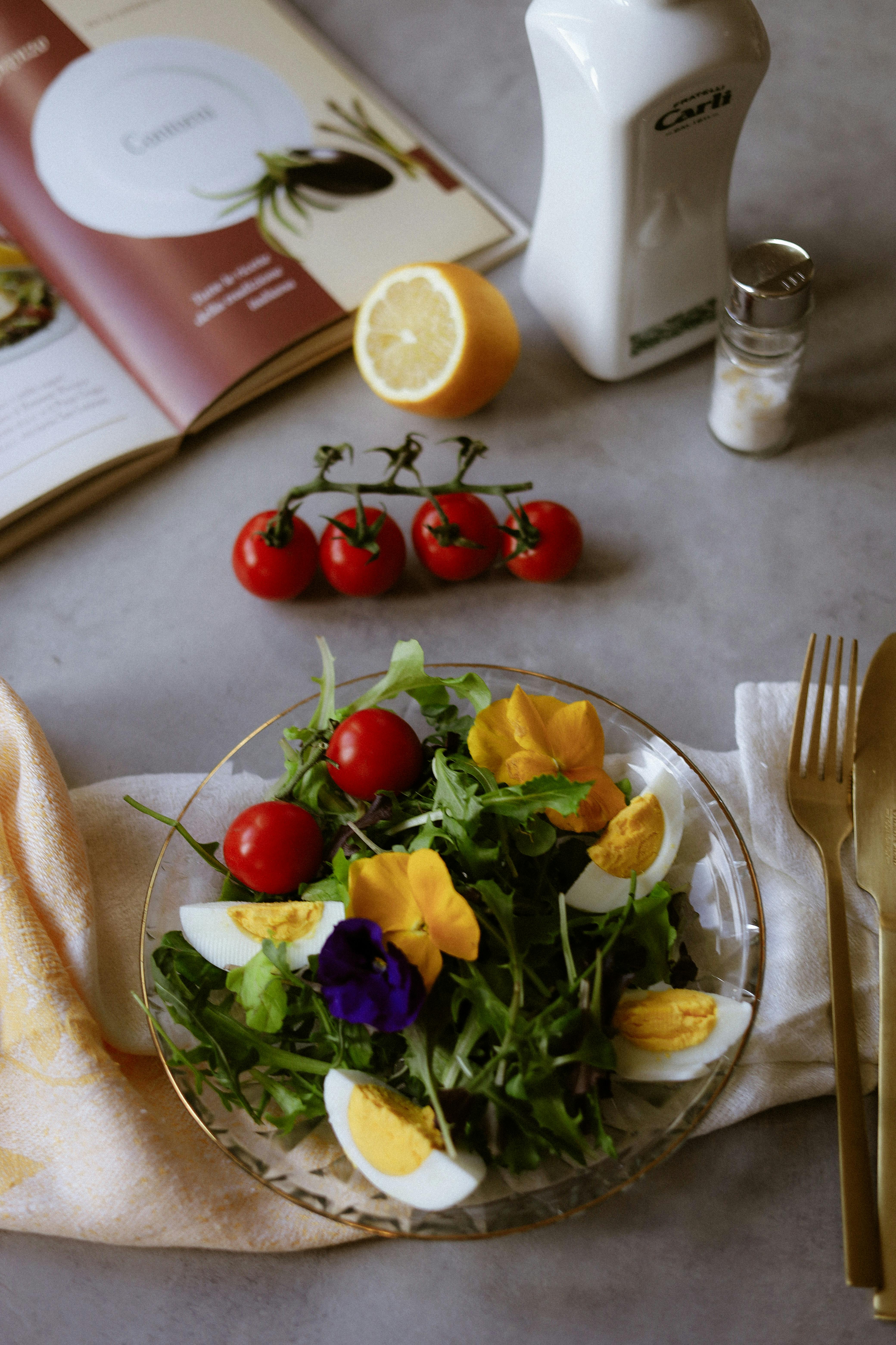 bezplatná Listový salát s rajčaty, jedlými květinami a vejci na prostírání. Základová fotografie