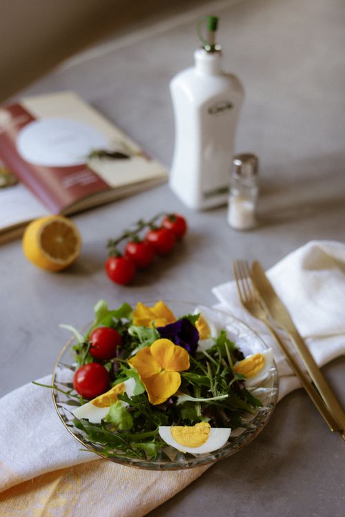 Free A vibrant spring salad with cherry tomatoes, arugula, eggs, and edible flowers. Stock Photo