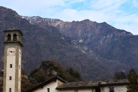 Scenic view of a historic bell tower against the Chiavenna mountains in Lombardia, Italy.