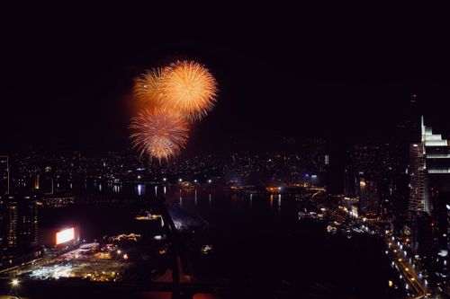Free A vibrant fireworks display lights up the night sky over Ho Chi Minh City, reflecting in the river. Stock Photo
