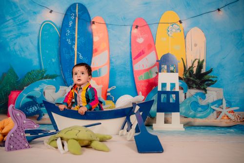 Free Adorable baby in a boat with surfboards, indoor beach theme for playful nursery decor. Stock Photo