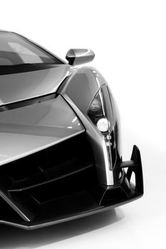 Detailed close-up of a luxury sports car front section in black and white.