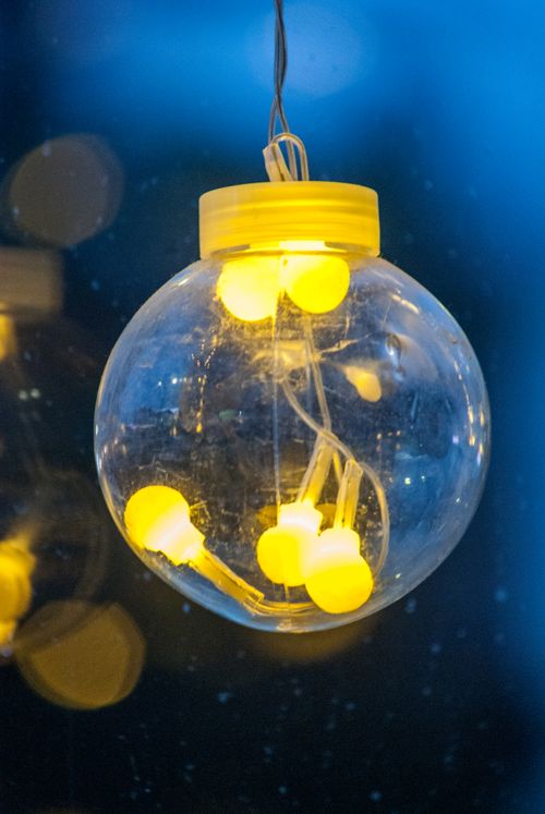 Free Close-up of a glowing Christmas ornament with warm yellow lights, exuding holiday cheer. Stock Photo