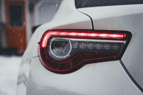 Free Detailed shot of a car's tail light in snow, showcasing modern design and weather conditions. Stock Photo