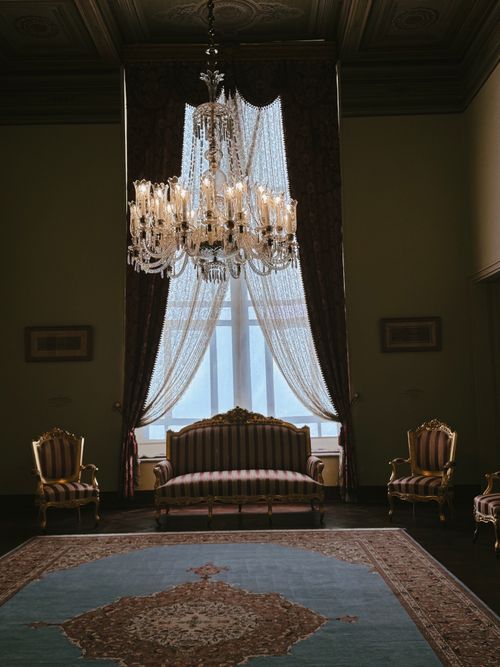 Free Luxurious room featuring a vintage chandelier and antique furniture setting. Stock Photo