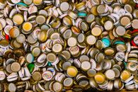 Close-up of multiple colorful bottle caps laid out for recycling and art projects.