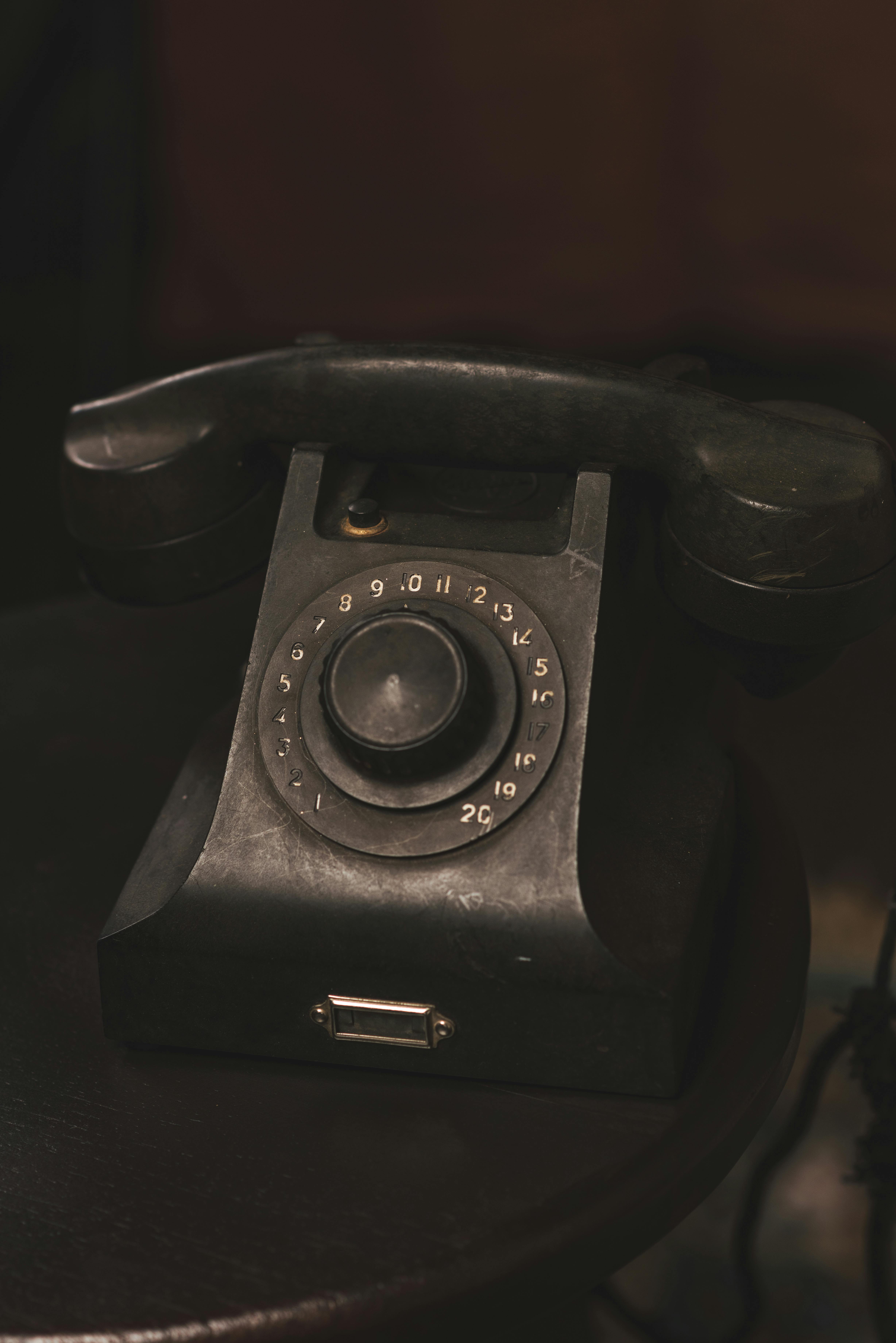 bezplatná Klasický vintage telefon s otočným číselníkem s náladovou, temnou atmosférou. Základová fotografie