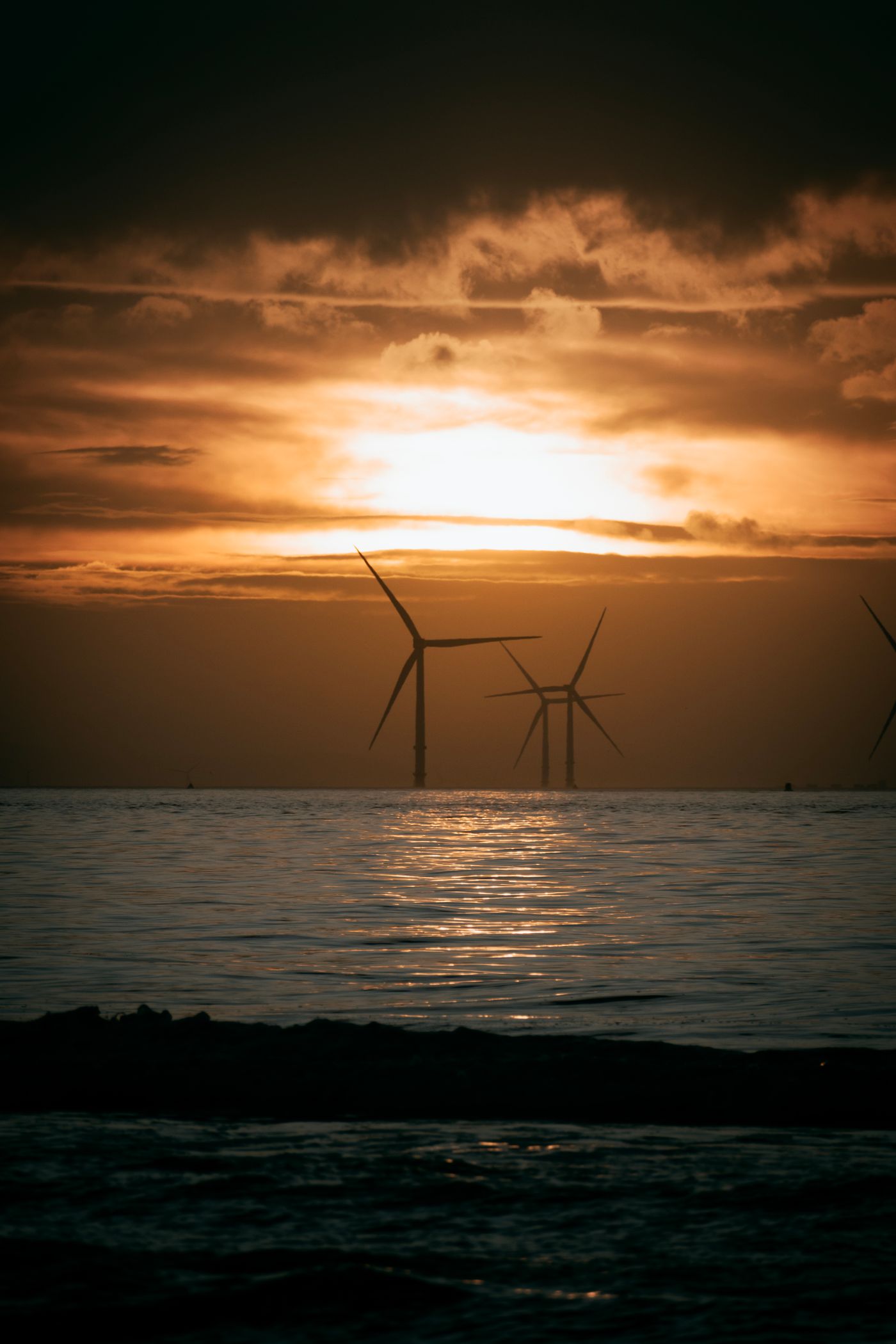 Offshore wind turbines silhouetted against a North Sea sunset