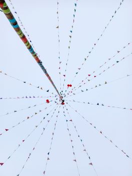 Festive triangular flags and balloons against a bright sky create a celebration vibe.