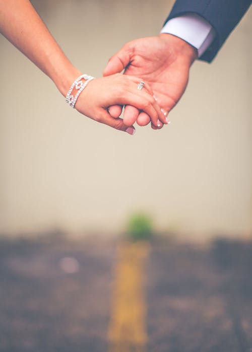 Photo of Man and Woman Holding Hands