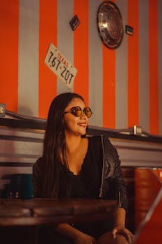 一位时尚女性戴着太阳镜，坐在一家装饰着德克萨斯州风格的复古咖啡馆里