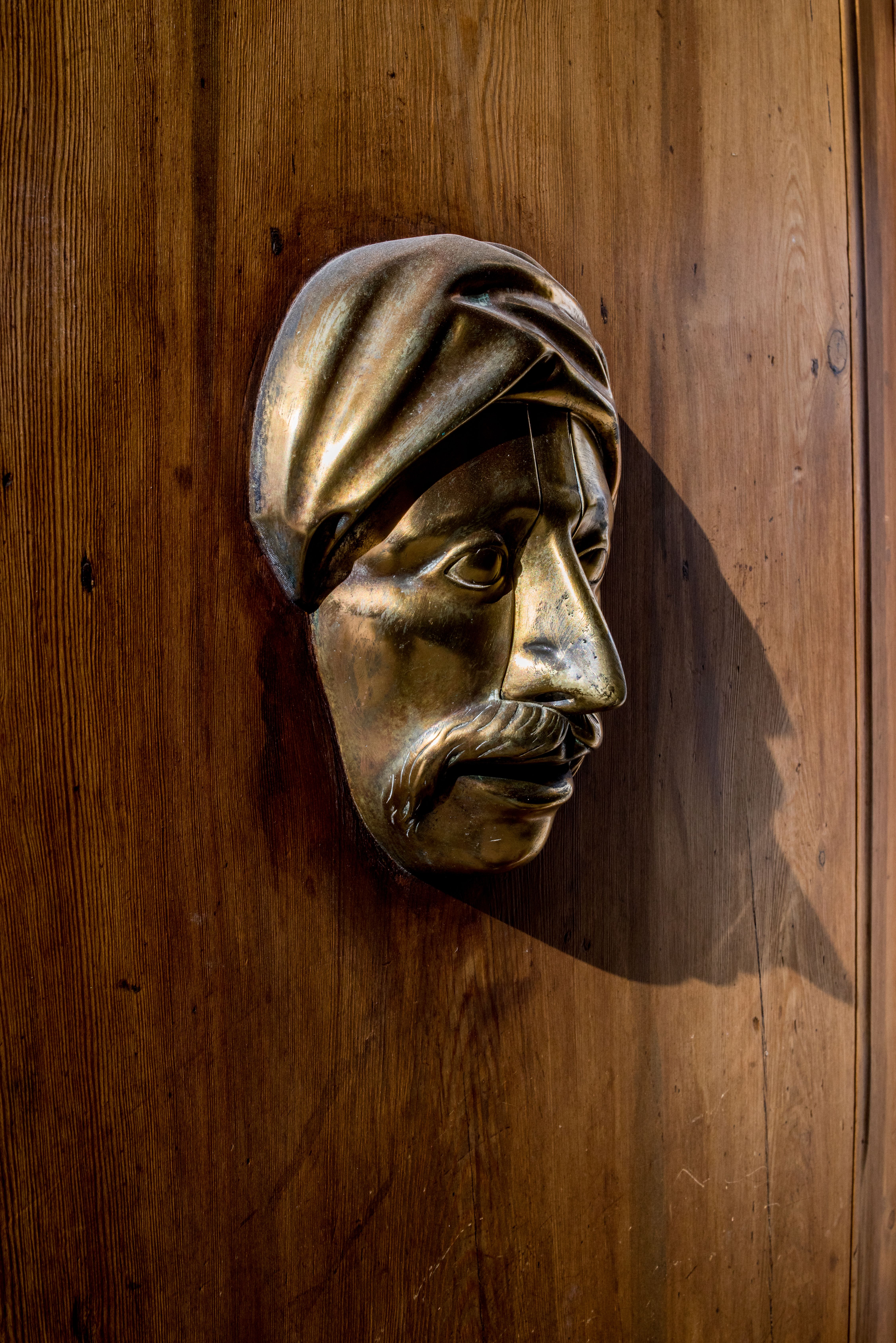 Antique Brass Door Knocker Shaped Like a Man's Face · Free Stock Photo