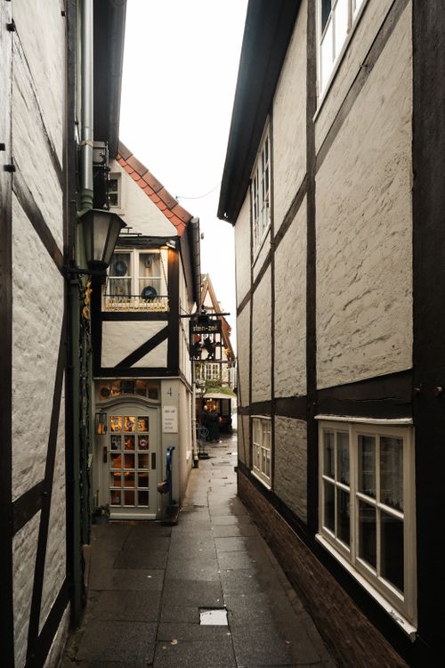 Free A narrow cobblestone street lined with half-timbered houses in Bremen, Germany's Old Town. Stock Photo