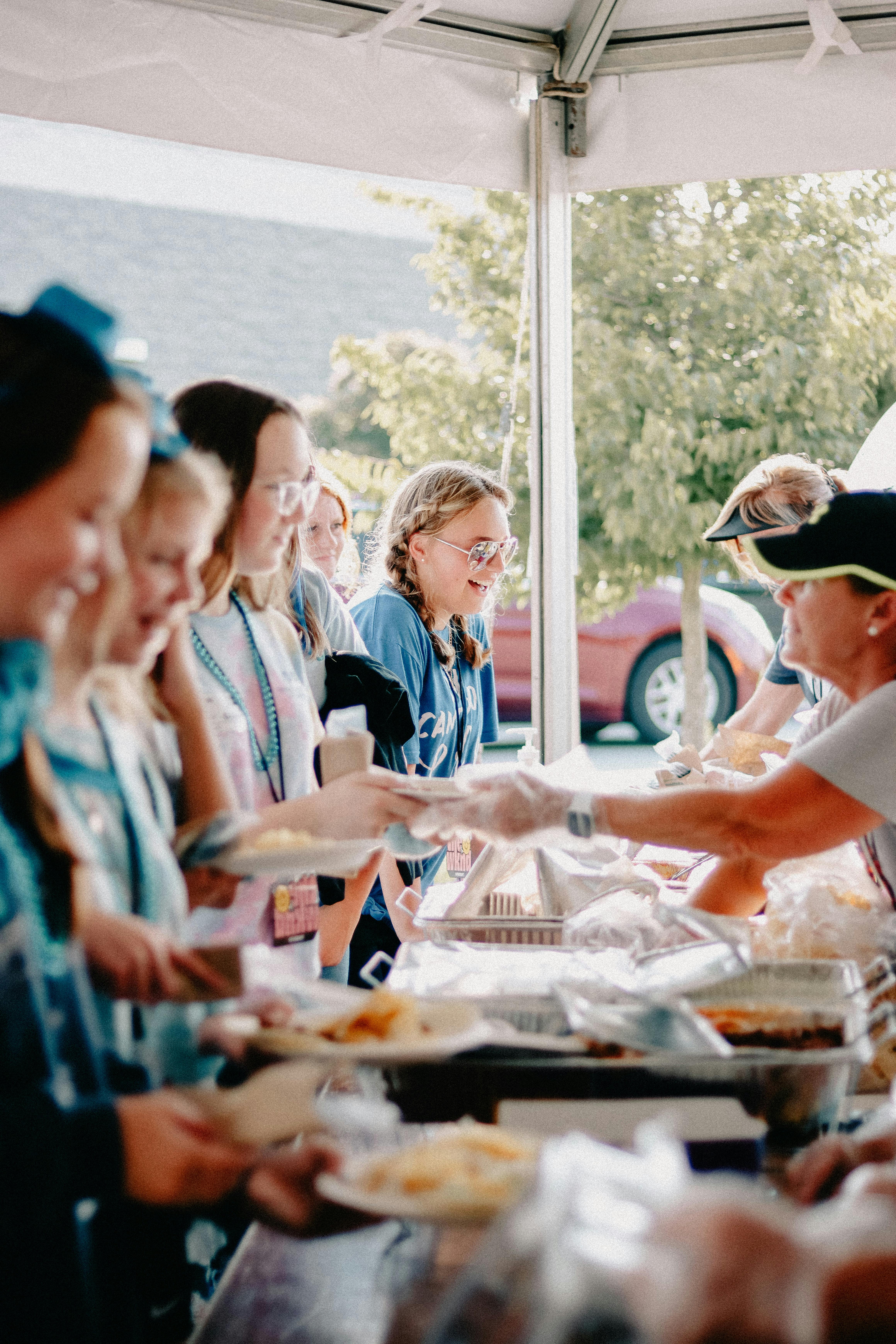 People enjoying an outdoor summer church meal, embracing fellowship and community.
