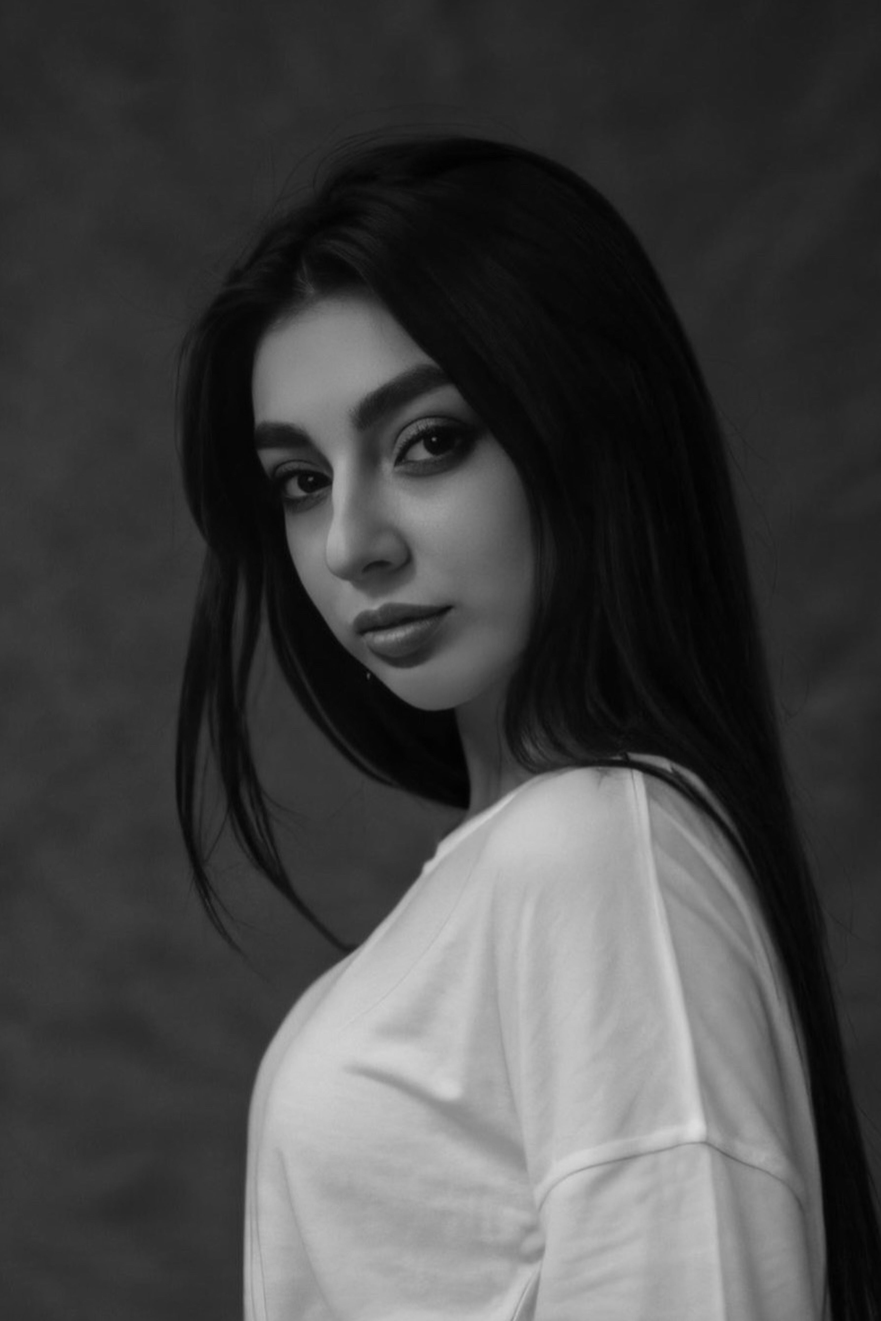 Black and white portrait of a woman with long hair in a soft, elegant pose.