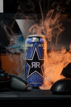 A vibrant energy drink can enveloped in swirling vape smoke, creating an edgy atmosphere.