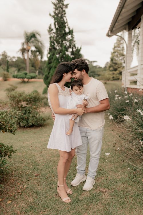 Free A family enjoying a tender moment outdoors in a beautiful garden scene. Stock Photo
