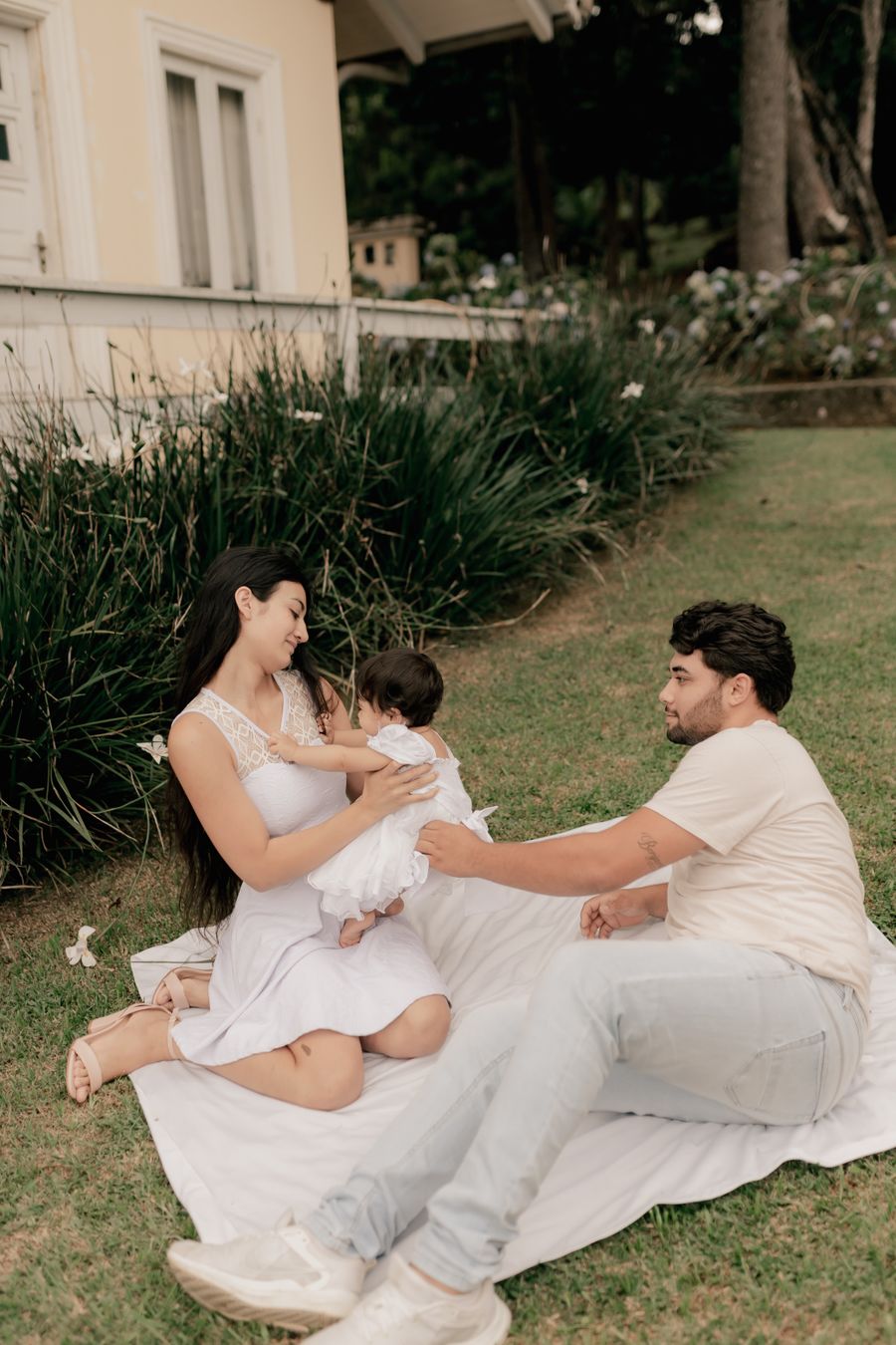 Young family relaxing together outside their home