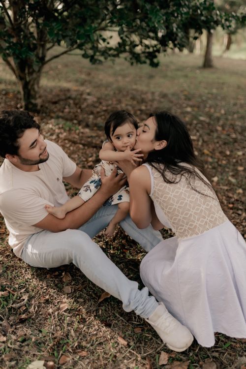 Free A loving family enjoying quality time outdoors under lush greenery. Stock Photo