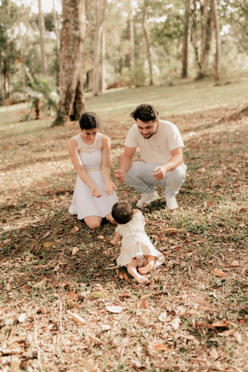 Free A joyful family moment with parents and baby in a serene forest setting. Stock Photo