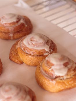 Close-up of freshly baked cinnamon rolls topped with creamy icing.