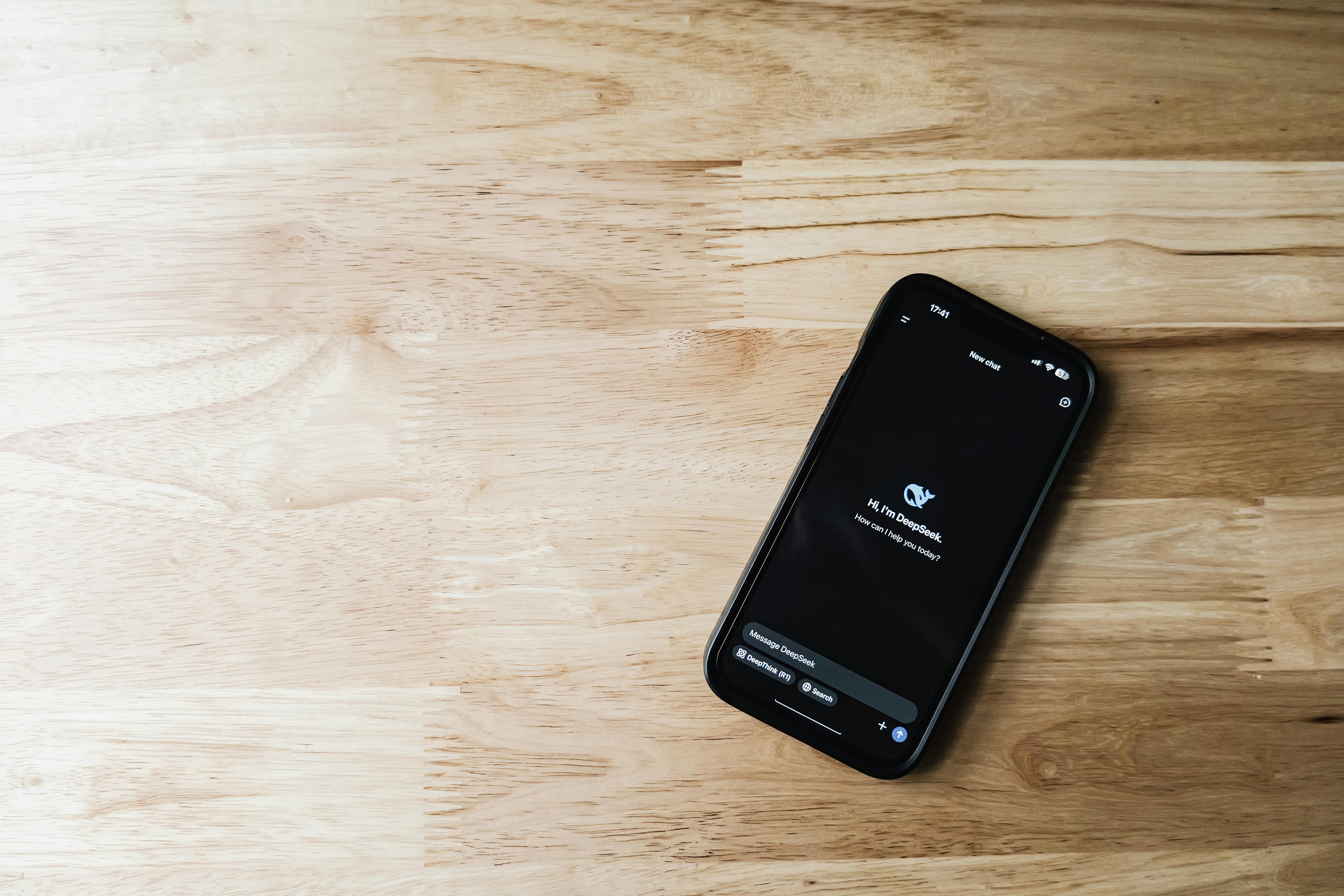 smartphone with chatbot interface on wooden surface